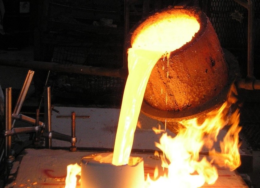 TT-Guss: On the path to digitizing inspection of casts The photo shows molten metal being poured from a bucket into a mold.