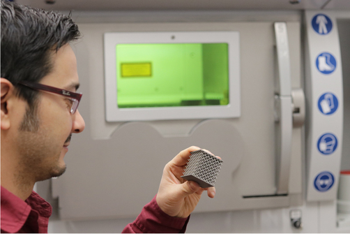 Additiv gefertigte Gitterstruktur, die von der Siemens AG, Power and Gas, Berlin, in einer Zusammenarbeit mit der BAM hergestellt wurde. Bild von einem Mitarbeiter der BAM mit Additiv gefertigter Gitterstruktur