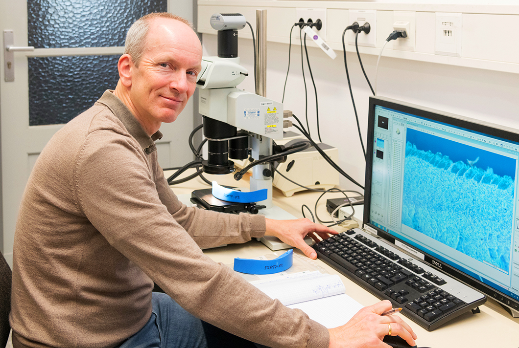  Dr. Dirk Bettge mit Materialprobe am Lichtmikroskop 