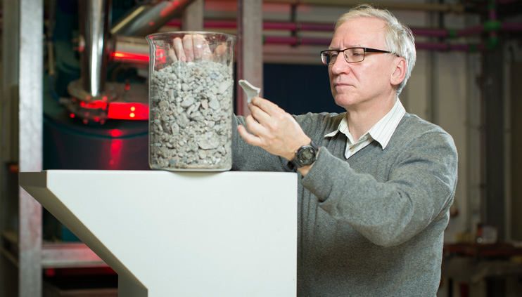BAM-Mitarbeiter mit einem Beh&auml;lter, gef&uuml;llt mit Asche aus verbranntem Hausm&uuml;ll.