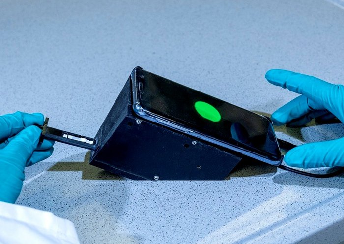 Eine Smartphone-Kamera misst das Leuchten des Teststreifens in dem tragbaren Messgerät und ermöglicht so eine schnelle und unkomplizierte Analyse der Wasserqualität. 