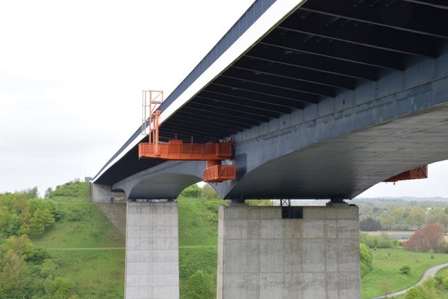 Eine Betonbr&uuml;cke mit einer unten angebrachten Wartungsplattform.