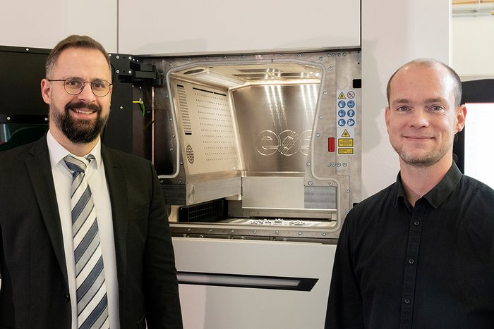 Dr. Kai Hilgenberg, Leiter des BAM-Kompetenzzentrums Additive Fertigung und Dr. Martin Epperlein, Koordinator des Pilotprojekts vor der neuen 3D-Druckanlage für Metalle (v.l.n.r.).