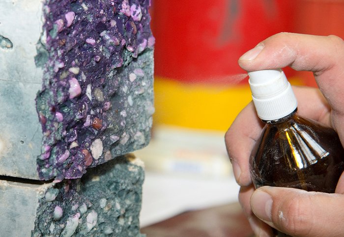 Spraying of phenolphthalein indicator solution to determine the depth of carbonation in alkali-activated concrete specimens