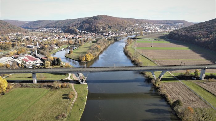 Paper of the Month 05/2023: TF Infrastructure The picture shows a concrete railway bridge spanning a river