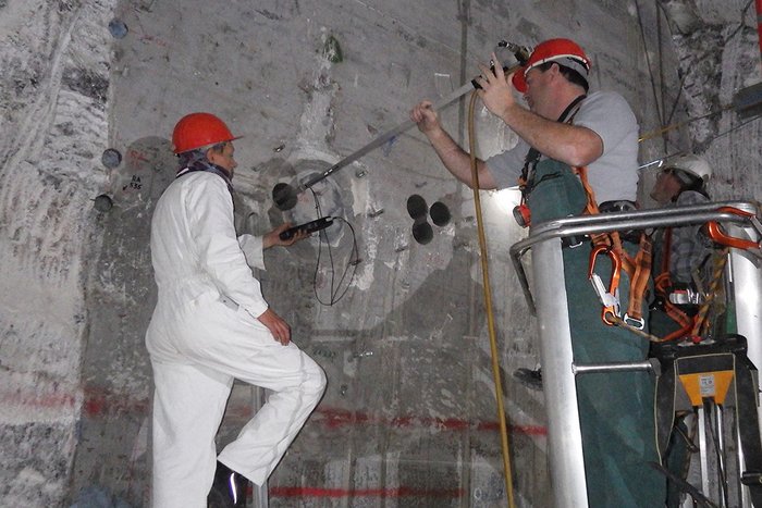 Zwei Ingenieure mit Ultraschall-Bohrlochsonde an einem Versuchsbauwerk in Morsleben
