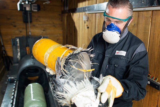 A BAM employee holds a burst yellow pressurised gas container in his hands. 