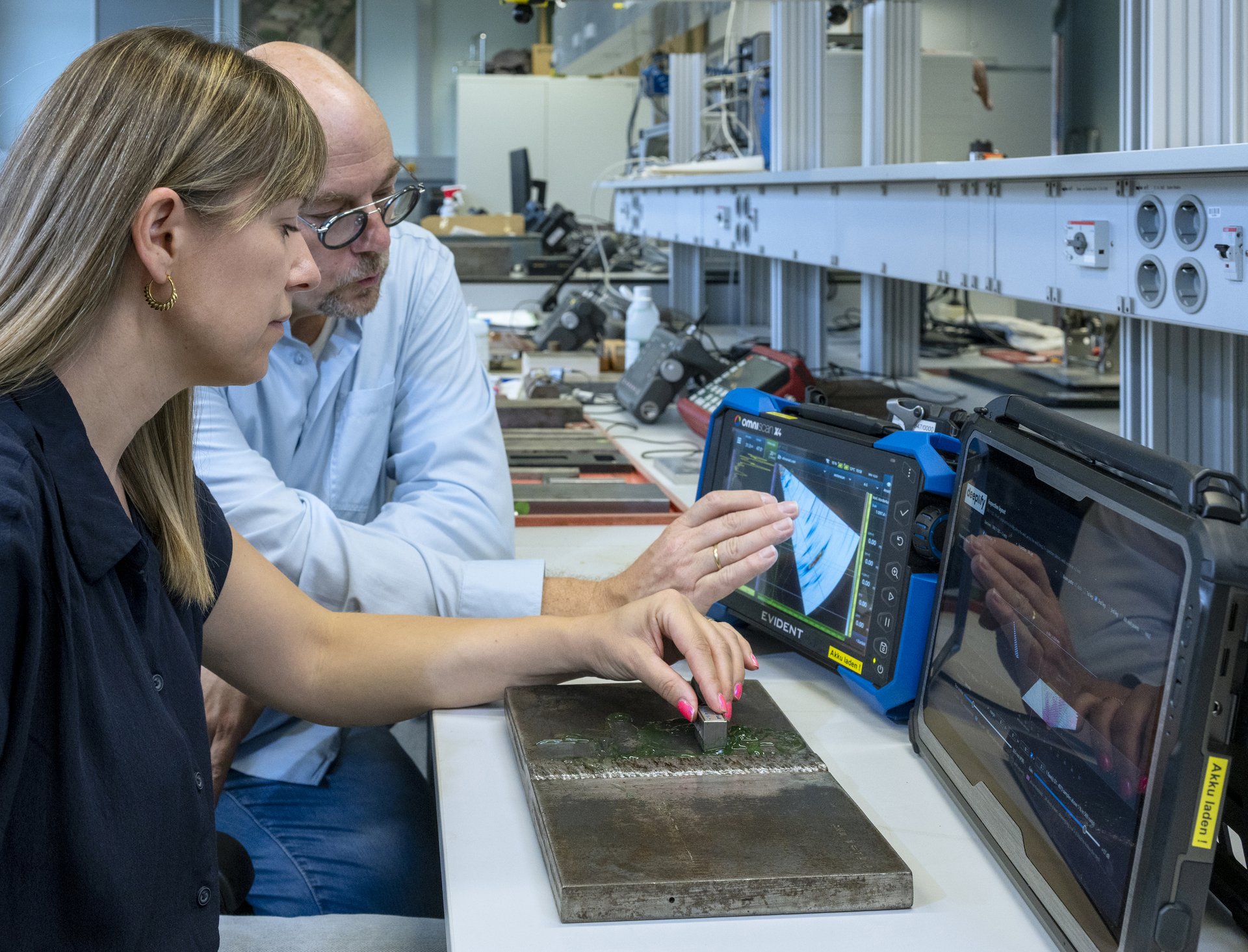 Eine Frau im Vordergrund und ein Mann im Hintergrund am Ultraschallpr&uuml;fplatz