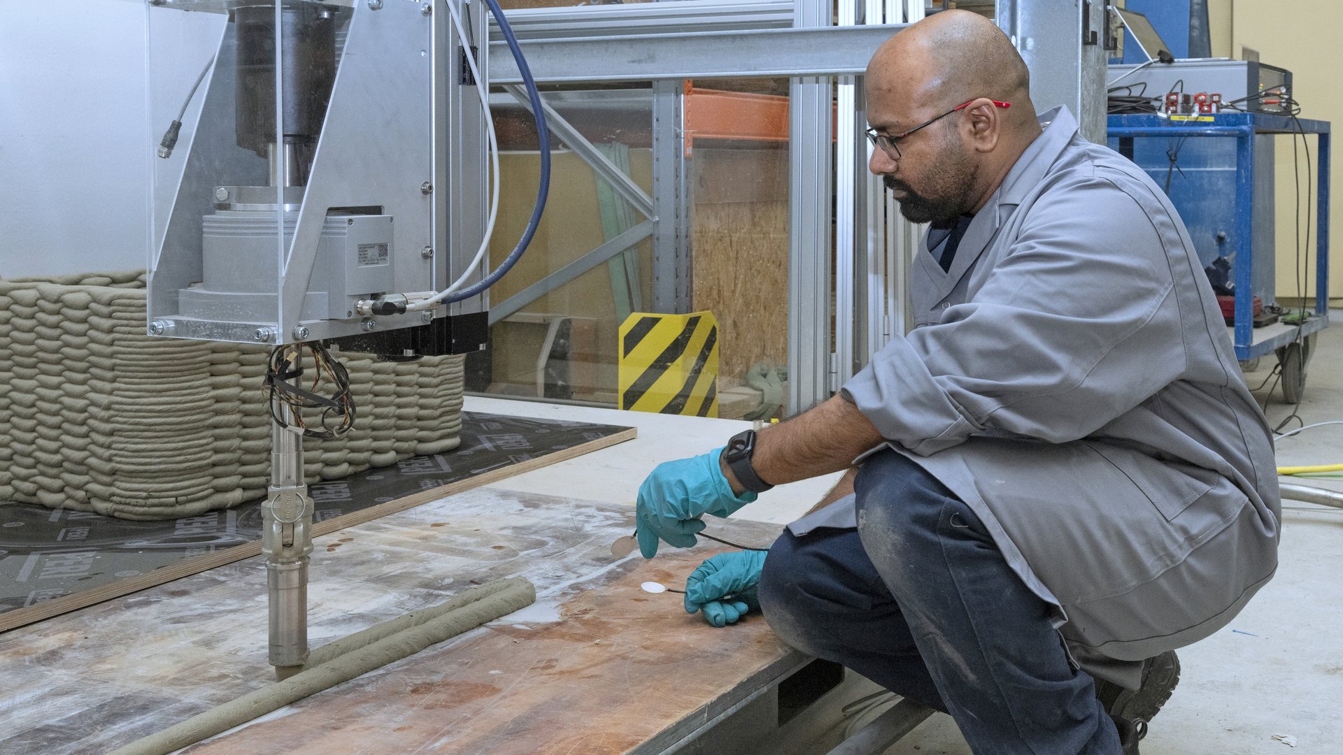 Amarteja Kocherla im Labor mit einem intelligenten Sensor und einem 3D-gedruckten Betonbauteilen.