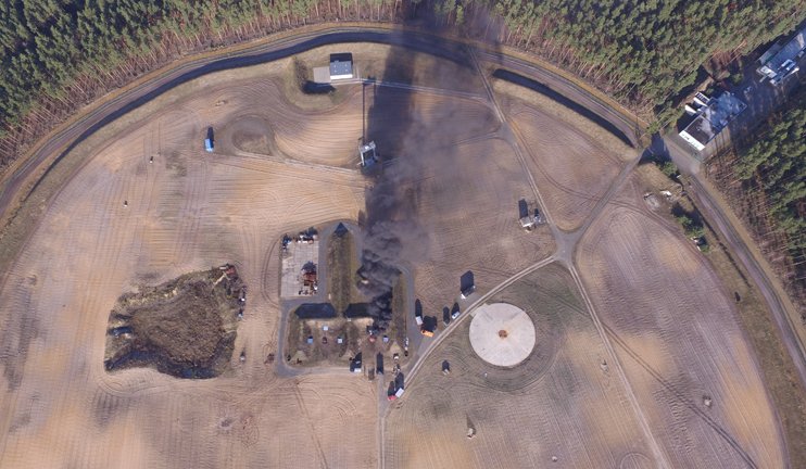 A bird's eye view of a fire test with a plume of smoke that is visible from a distance. Tile preview