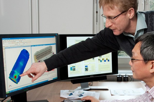 Dr. Holge V&ouml;lzke (standing) and Dr. Linan Qiao assess the simulation of a container for highly radioactive waste.