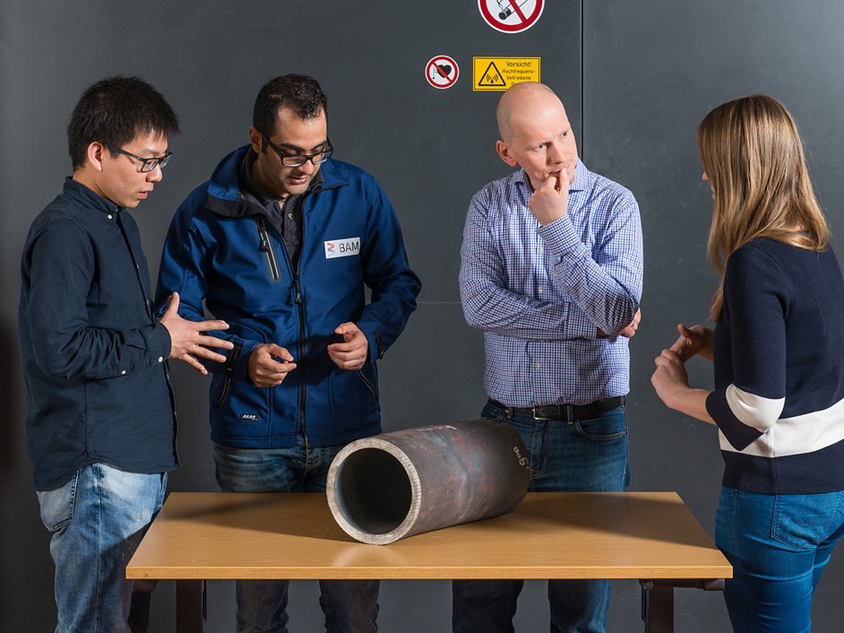 The team around Dr.-Ing. J&uuml;rgen Olbricht examines a piece of a power plant steam line (from left to right: Dong Wang, Dr.-Ing. Hamed Ravash, Dr.-Ing. J&uuml;rgen Olbricht and Maria J&uuml;rgens).