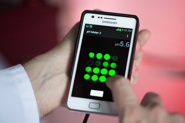 Ein BAM-Mitarbeiter h&auml;lt ein Smartphone mit einem PH-Schnelltest in der Hand.
