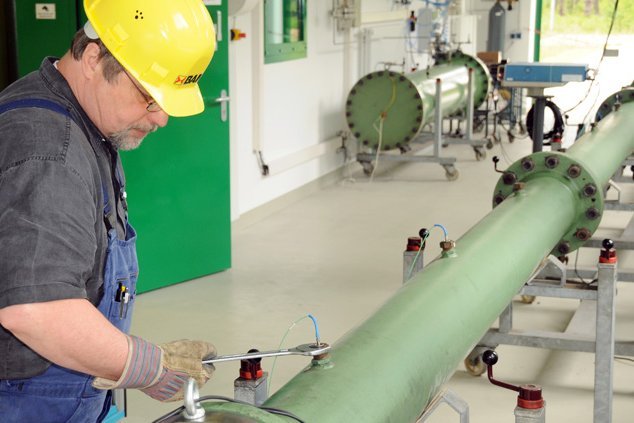 Ein BAM Mitarbeiter bereitet eine Rohrleitung f&uuml;r einen Gas-Explosionsversuch vor.