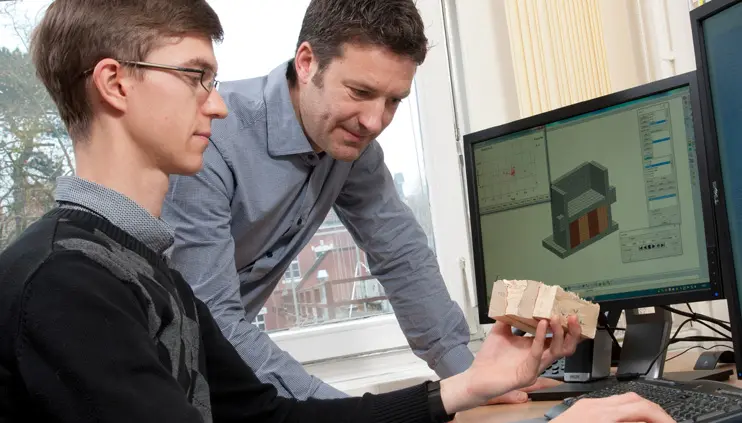 BAM Wissenschaftler am Rechner. Vergleich einer gestauchten Holzprobe mit der Computersimulation.