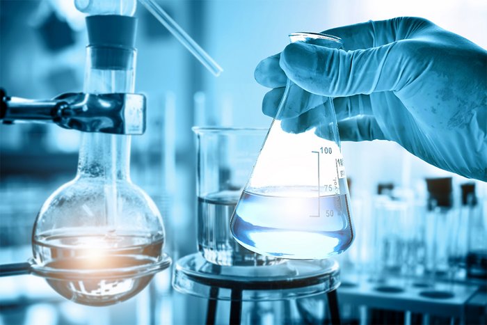 Hand des Wissenschaftlers h&auml;lt Kolben mit Laborglas in chemischen Labor Hintergrund