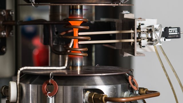Und so sieht die der Versuchsaufbau im Detail aus: Die s&auml;ulenf&ouml;rmige Stahl-Probe wird - fest eingespannt - Druck und Zug ausgesetzt. Angelegte Sensoren messen die entstehenden Ver&auml;nderungen im Metall. Kachel Vorschau