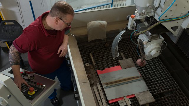 Daf&uuml;r wird das zuzuschneidende Metallst&uuml;ck in die Wasserstrahlschneideanlage eingelegt... Kachel Vorschau