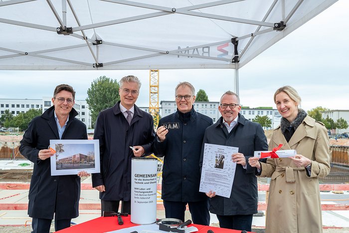 Im Rahmen der feierlichen Grundsteinlegung befüllen die Projektbeteiligten die Zeitkapsel für den Labor- und Forschungsneubau der BAM in Berlin-Adlershof.